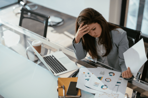 woman sitting at desk with laptop and seo charts worrying